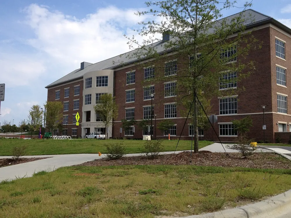 Ross Hall, the East Carolina University School of Dental Medicine building in Greenville, NC — a daytime, landscape exterior of the brick building under a blue sky.