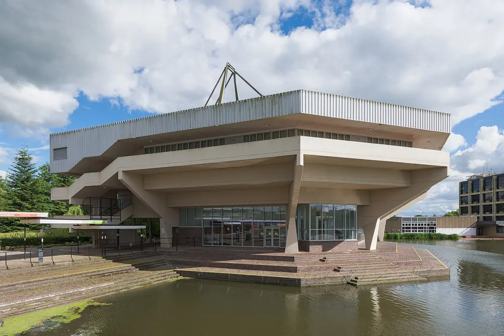Central Hall, University of York (Heslington campus) — the university's iconic modernist hall reflected over the campus lake; York is the host campus of Hull York Medical School (HYMS).