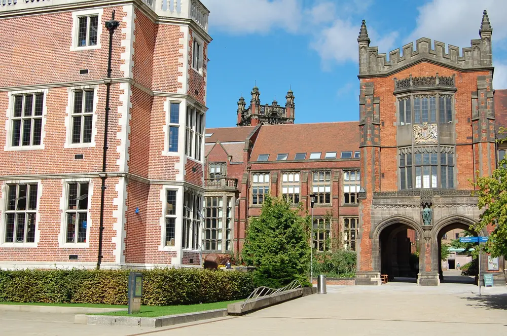 Newcastle University campus quad — the Arches gatehouse (with royal coat of arms) and the historic Armstrong Building