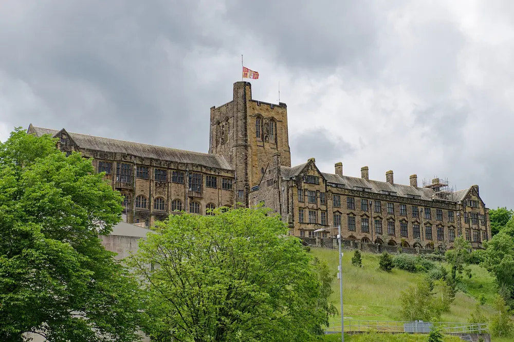 Main Arts Building (former University College of North Wales), Bangor University, with its landmark clock/bell tower, viewed across green trees and hillside