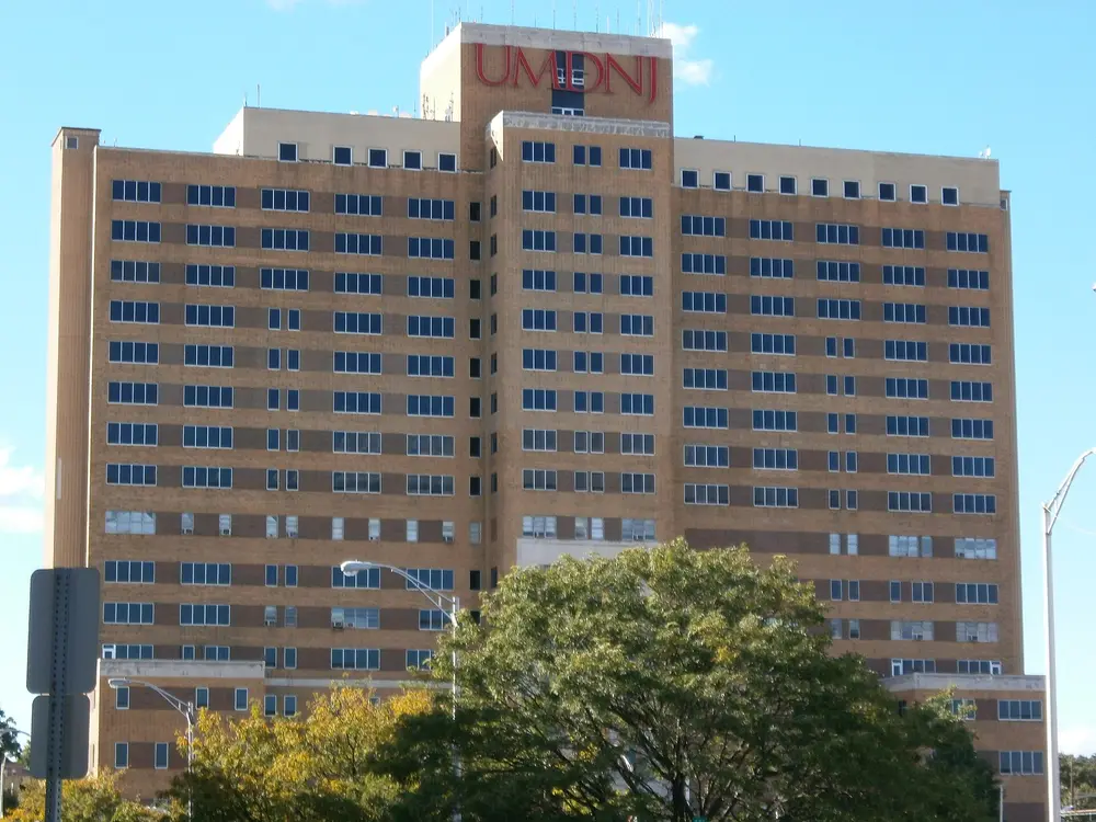 The Bergen Building on the Rutgers Newark health sciences campus (110 Bergen Street), which houses the Rutgers School of Dental Medicine — a large brick tower against a clear blue sky.