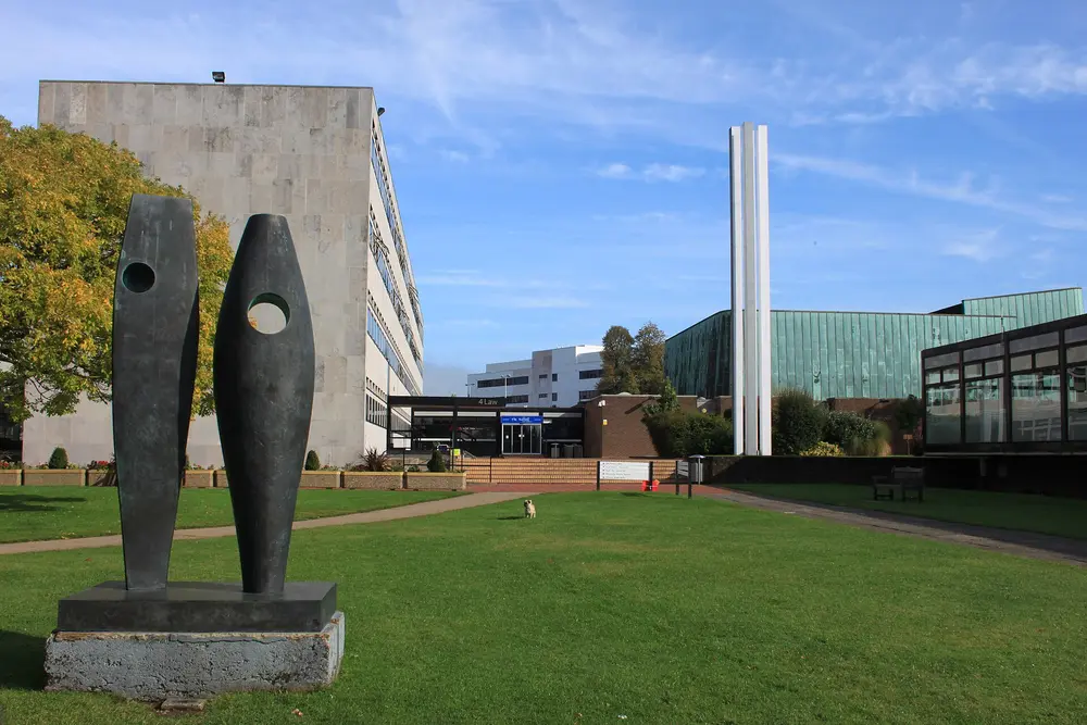 Highfield Campus, University of Southampton — main campus green with the Barbara Hepworth sculpture, campus buildings and the sculptural white spire under a blue sky