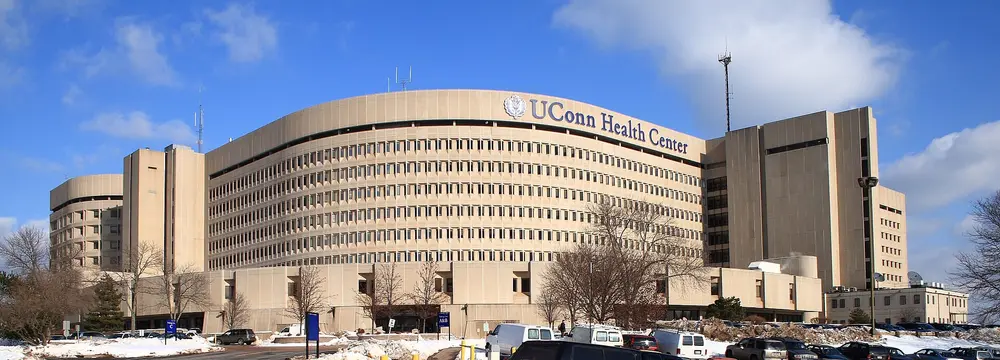 Daytime exterior of the UConn Health Center main building (John Dempsey Hospital tower) in Farmington, CT, the academic medical center housing the University of Connecticut School of Dental Medicine.