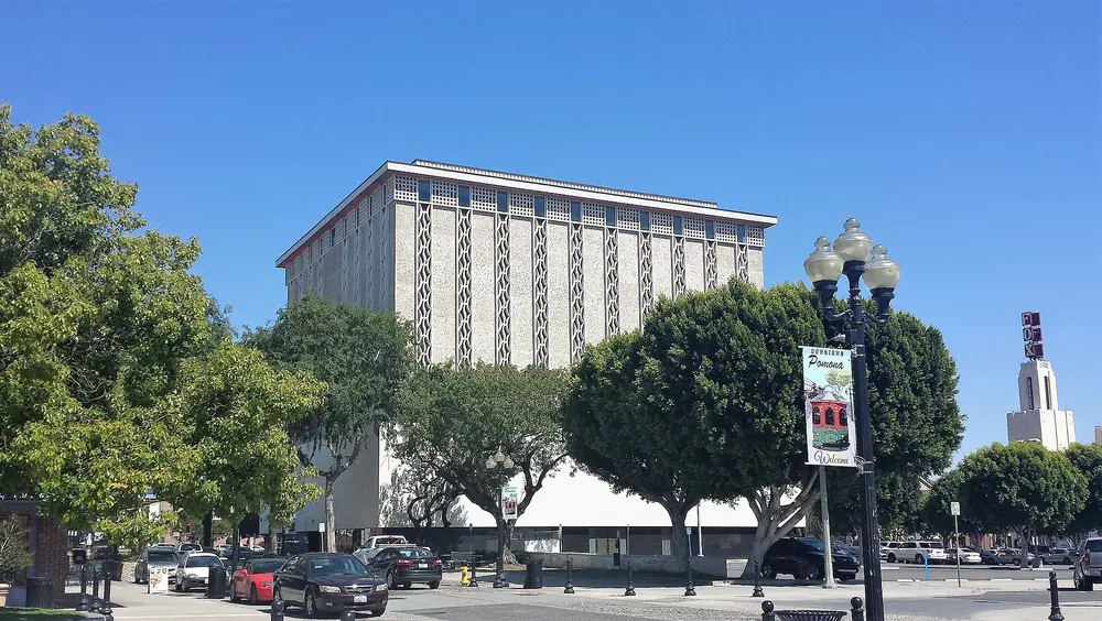 Anderson Tower, the distinctive landmark academic building at Western University of Health Sciences in downtown Pomona, CA (parent institution of the College of Dental Medicine), shot in daytime with clear blue sky and green trees.