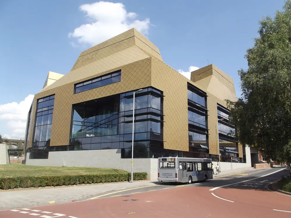 The Hive, University of Worcester — the university's iconic gold-clad library building, full exterior against a blue sky